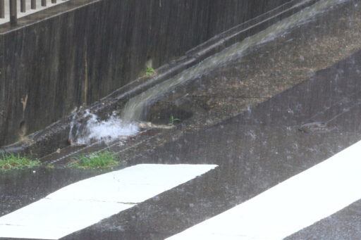 大雨で側溝に雨水が集中してしまう様子